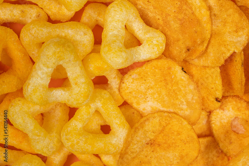 Crispy potato and corn chips, close-up view from above.