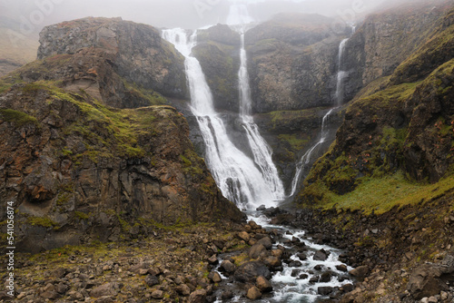 Large waterfall located in the East Fjords in Iceland. Horizontal composition using a slow exposure speed to capture the movement of the water