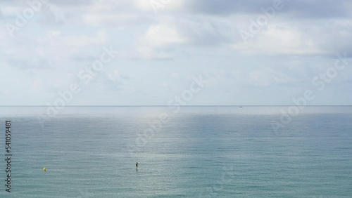 Lone paddle surfer on calm Mediterranean sea