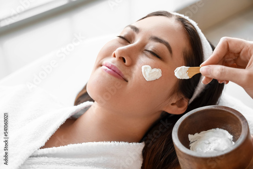 Beautician applying mask on...