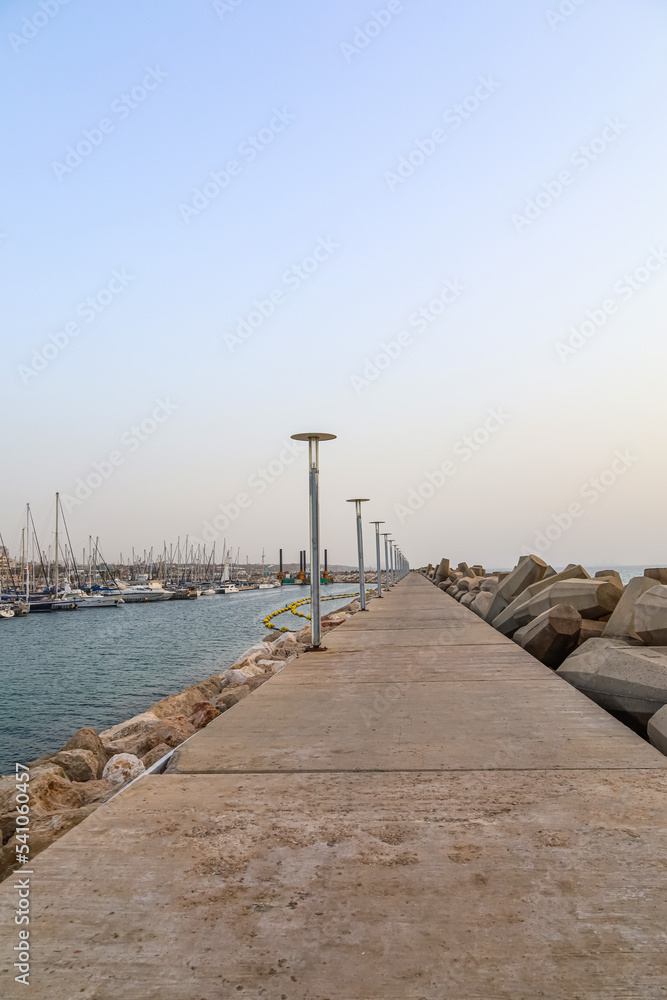 View of beautiful pathway with lamps near sea View of beautiful pathway with lamps near sea