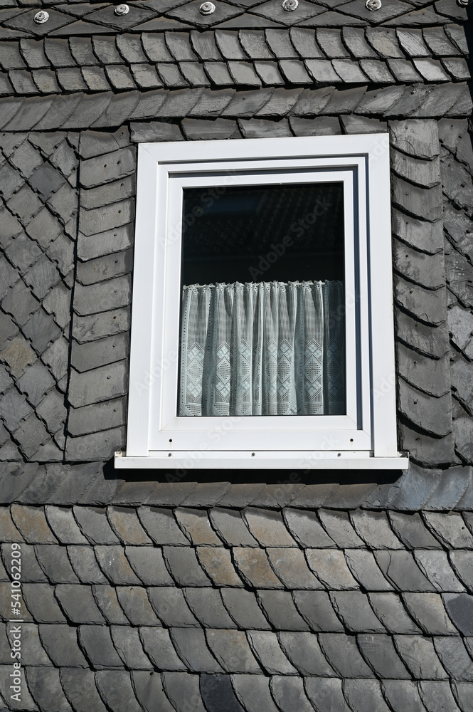 Fototapeta premium Slate wall siding on a house with a white window
