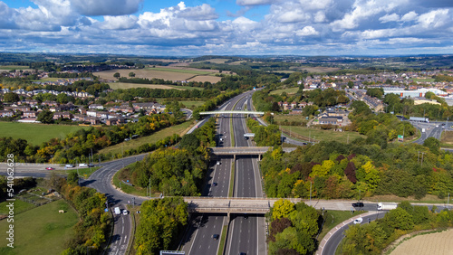 Aerial drone photo of the busy M1 motorway with three bridges crossing over the highway in the village of Barnsley in Sheffield UK in the summer time on a bright sunny summers day. photo