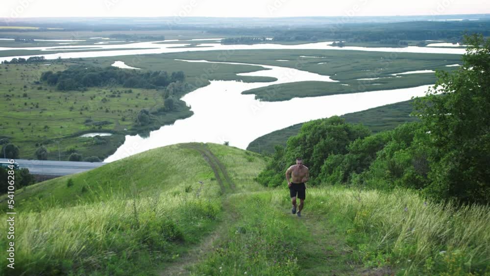 A muscular shirtless man jogging up the hill A muscular shirtless man jogging up the hill