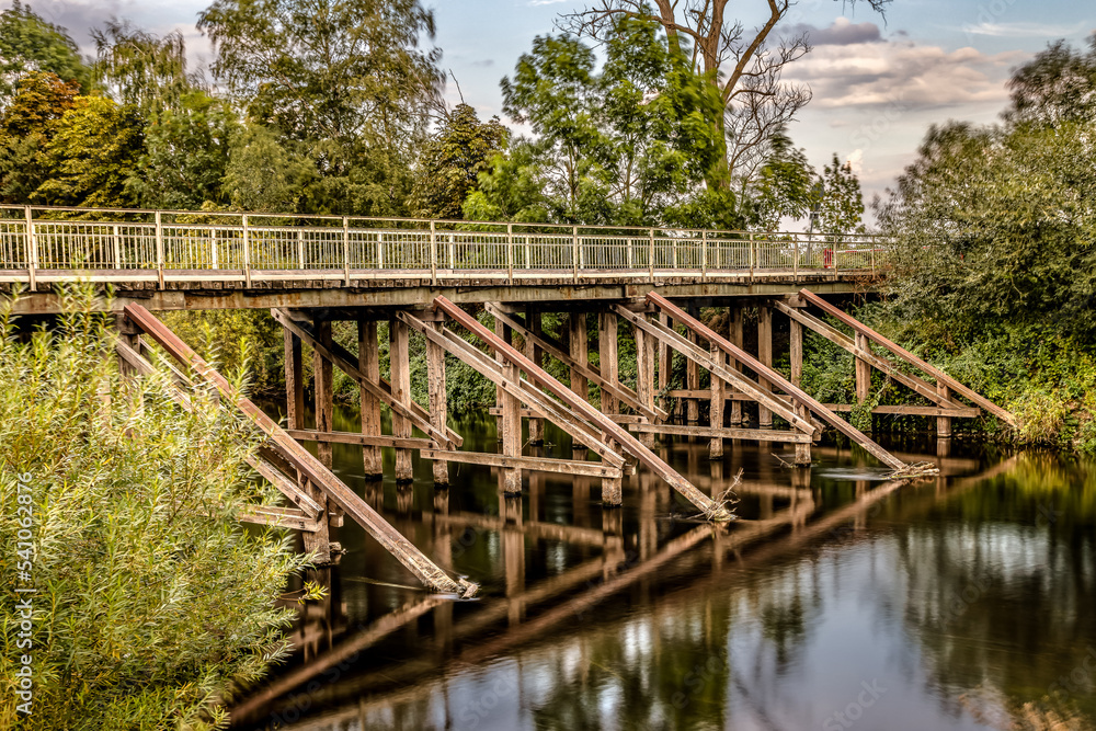 Bridge on the Leine in Schliekum near Sarstedt. reflection in the water. Radiant sunshine. Bridge on the Leine in Schliekum near Sarstedt. reflection in the water. Radiant sunshine.