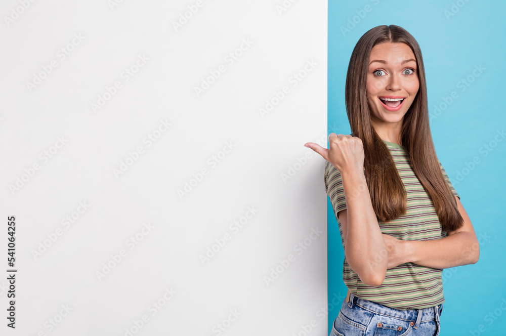Photo of positive impressed woman with long hairstyle wear striped t-shirt directing empty space isolated on blue color background Photo of positive impressed woman with long hairstyle wear striped t-shirt directing empty space isolated on blue color background