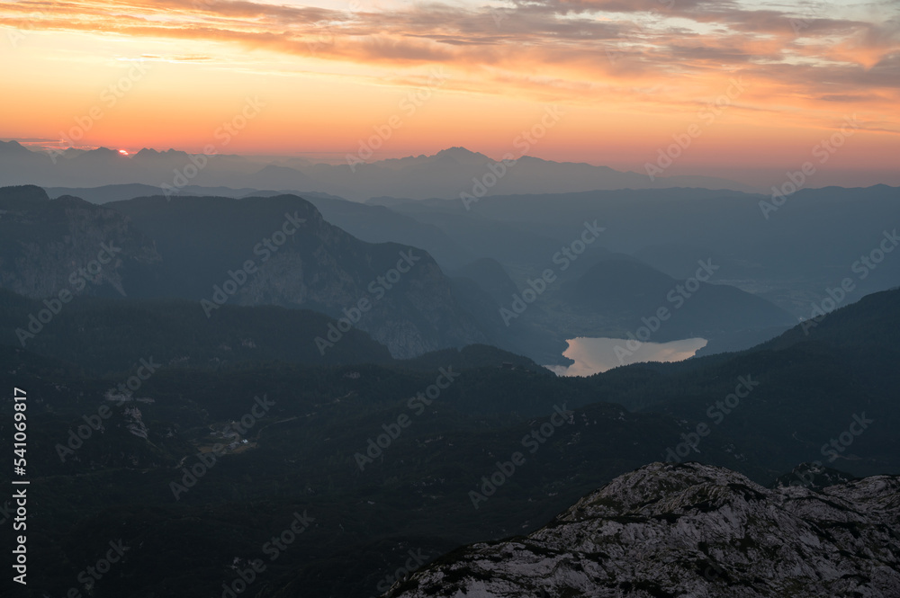 Spectacular sunrise with sun rising above lake Bled as seen from the mountains.