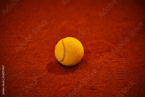 yellow tennis ball lies on a dark map