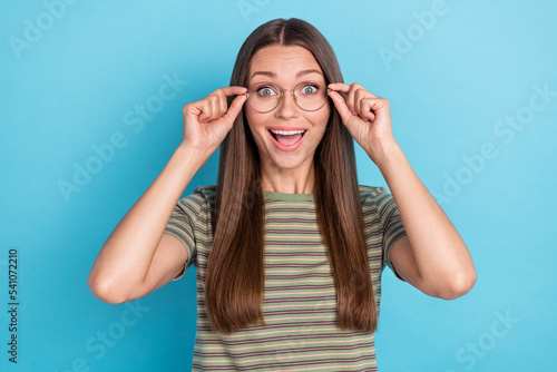 Photo of gorgeous satisfied impressed girl with long hairstyle wear striped t-shirt buy new glasses isolated on blue color background