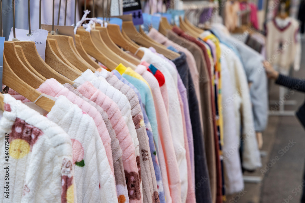 A shopping rank filled with clothes, pajamas and robes. Bunch of clothes of different colors for sale. Cheep clothing and fast fashion theme A shopping rank filled with clothes, pajamas and robes. Bunch of clothes of different colors for sale. Cheep clothing and fast fashion theme