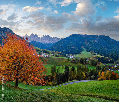Autumn daybreak Santa Magdalena famous Italy Dolomites village view in front of the Geisler or Odle Dolomites mountain rocks. Picturesque traveling and countryside beauty concept background.