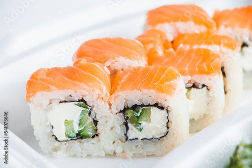 Philadelphia roll in plastic container on white background. Uramaki rolls.