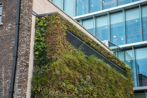 Photography Green ecological facade of skyscraper covered in plants in capital Dublin