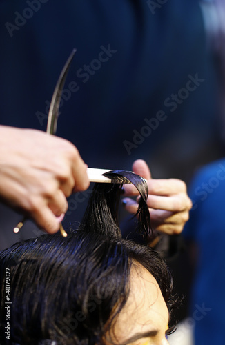 manos de peluquera cortando el pelo con tijera