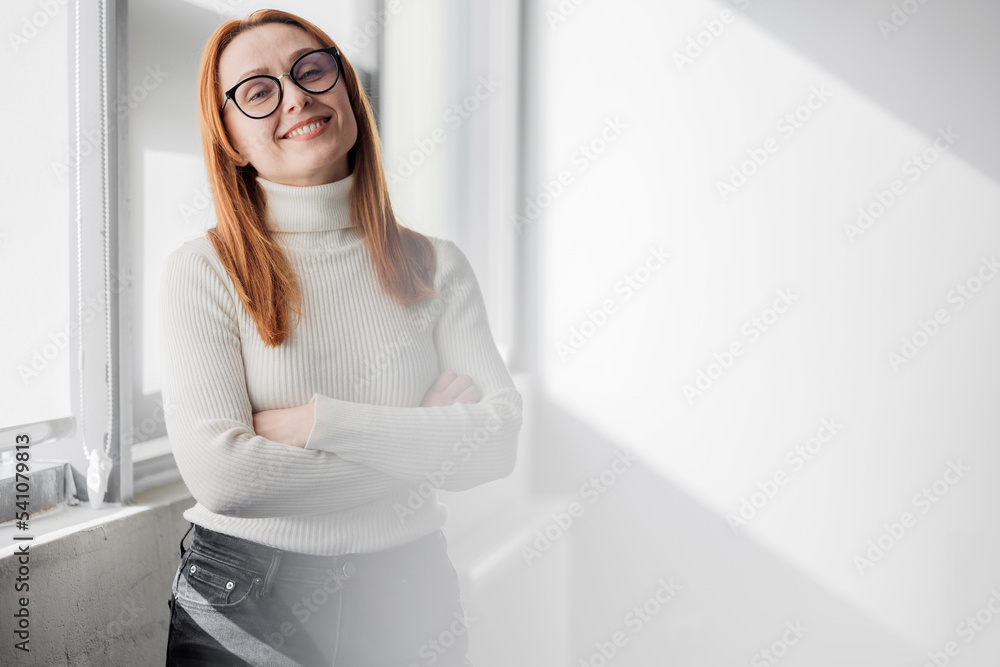 European woman in her middle age who exudes confidence and style standing at work. Elegant elder senior businesswoman, executive leader manager in office photo looking at camera.