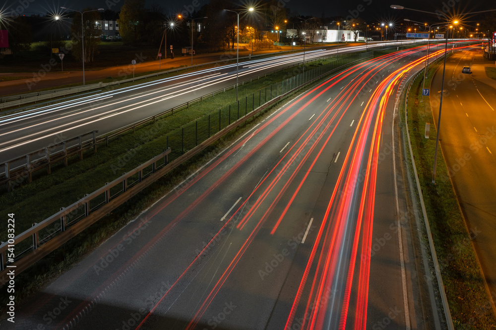 Cars blurred lighting traces on night on roadway from Riga to resort city Jurmala. Shot from bridge over way. Cars blurred lighting traces on night on roadway from Riga to resort city Jurmala. Shot from bridge over way.