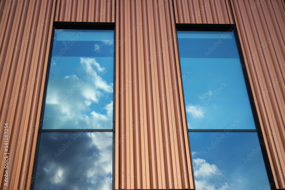 Blue sky and clouds reflected in windows of modern building, Gdansk, Poland Blue sky and clouds reflected in windows of modern building, Gdansk, Poland