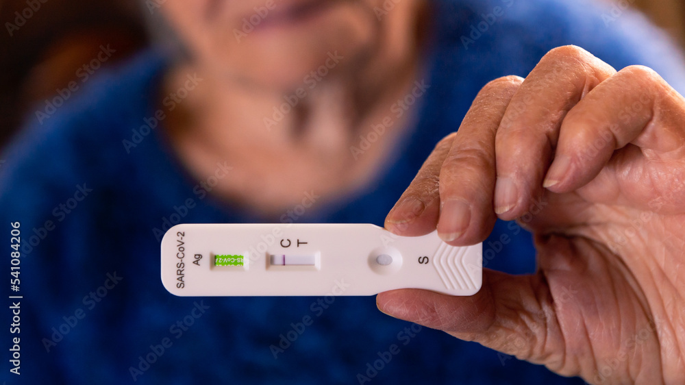 Obraz premium Grandma makes a rapid home test device for Covid19 virus with a negative result