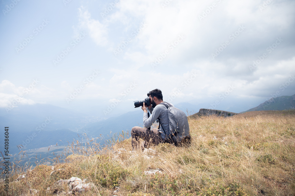Photographer on mountain. Nature photographer taking photo