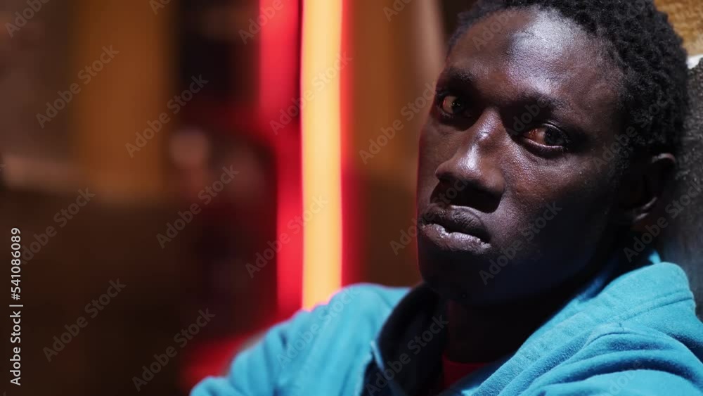 Sad and depressed African American man sitting on the ground on the night Sad and depressed African American man sitting on the ground on the night