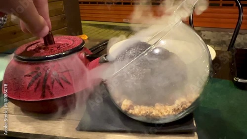 video of a kettle with liquid nitrogen vaporizing black truffle ice cream photo