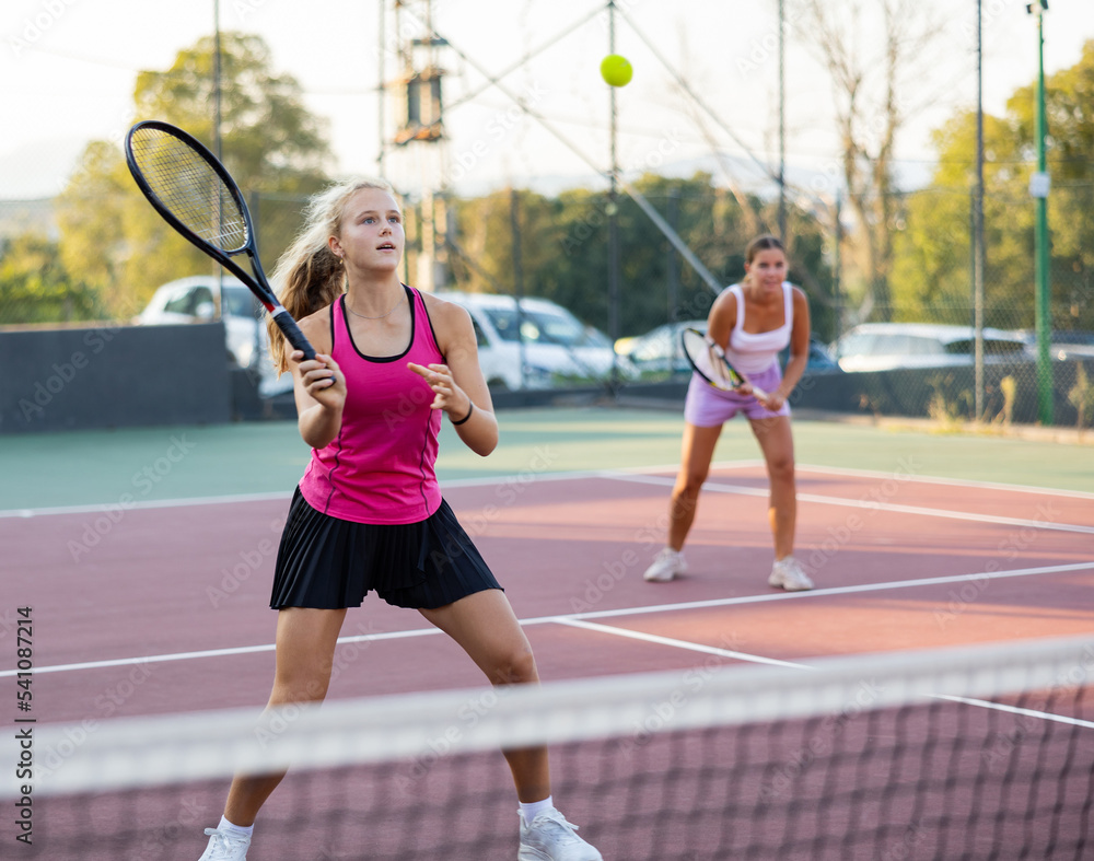 Tennis game - girl actively kicks the ball during a tennis game