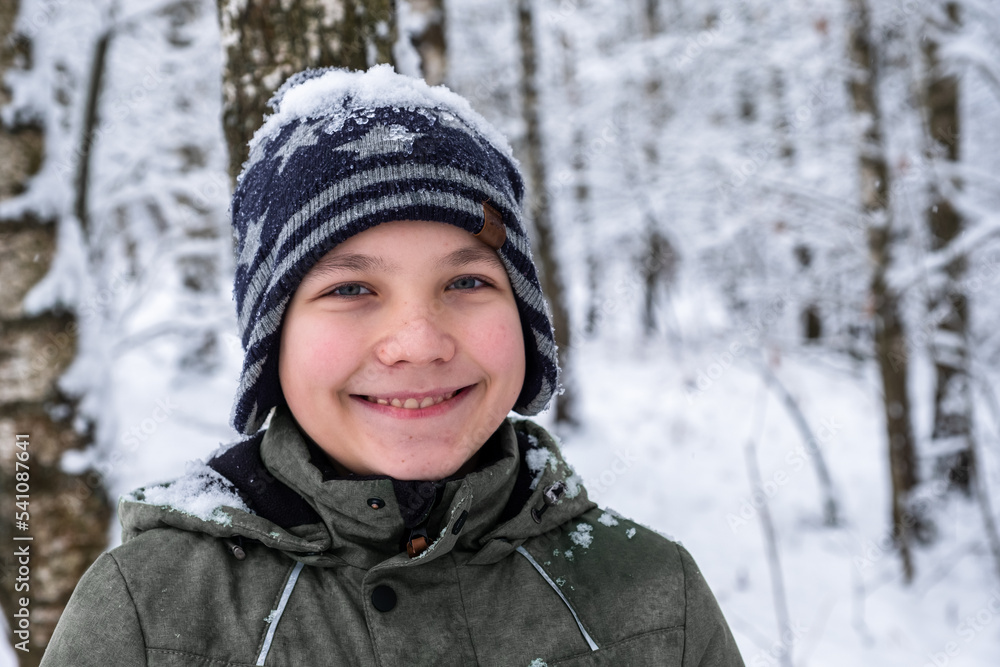 portrait of a smiling boy on the background of a winter forest portrait of a smiling boy on the background of a winter forest