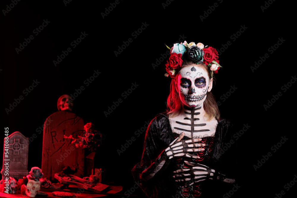 Scary lady of death with festival make up and halloween costume to  celebrate dios de los muertos mexican holiday. Spooky woman as santa muerte  with flowers crown, day of the dead. Stock