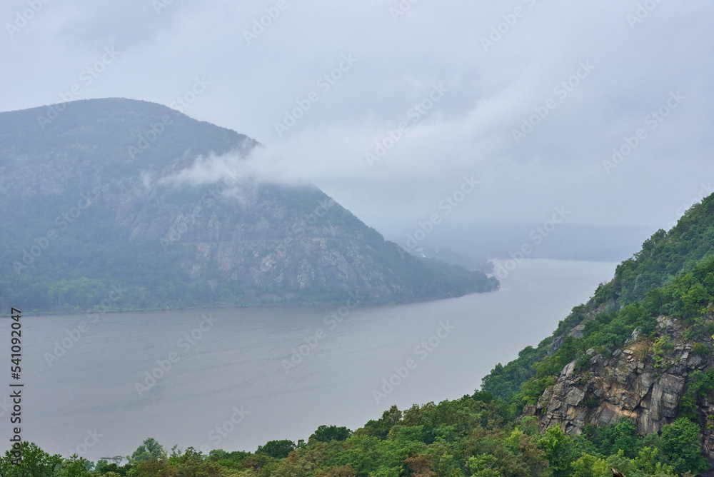 Storm King Mountain, seen from Hudson Highlands State Park across the Hudson River on a foggy and rainy day.