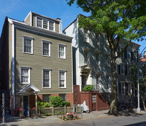 Three early 19th century wood frame houses on Middagh Street in Brooklyn Heights, NYC with clapboard facades.