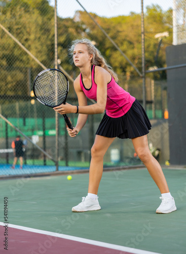 Woman tennis player training on court. Woman using racket to hit ball. © JackF