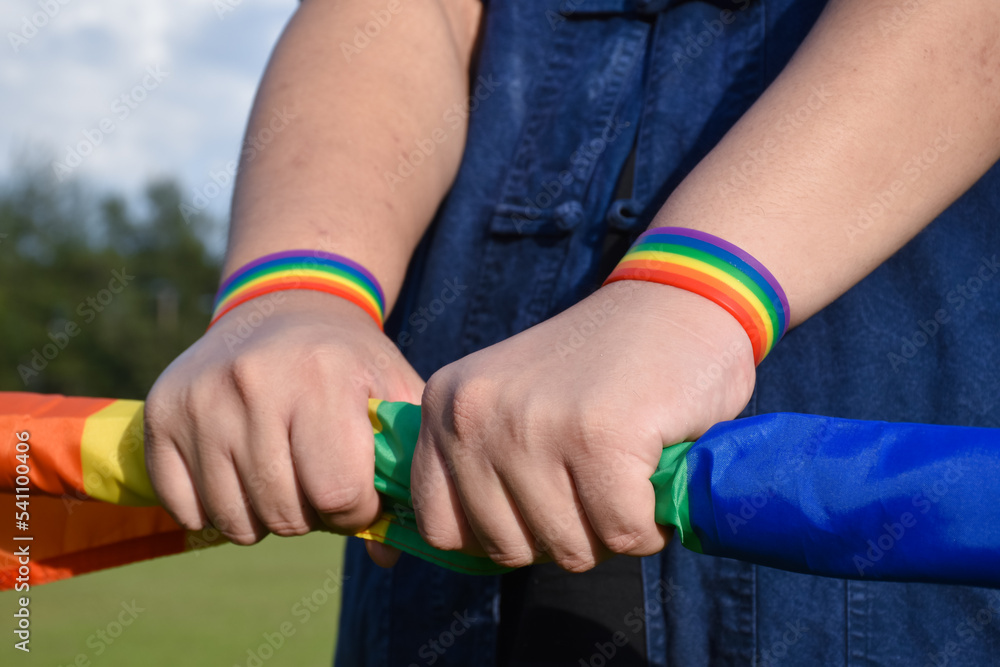 Rainbow wristband on right and left hand, soft and selective focus
