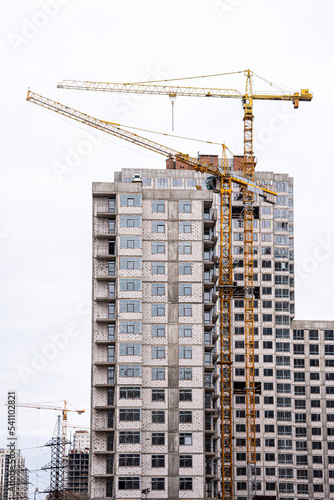 Crane and building under construction against white sky