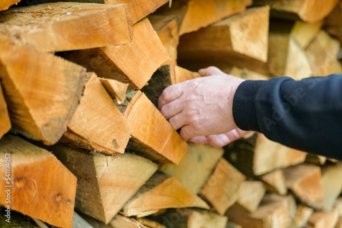 Firewood and mens hands. solid fuel.Male hands pulling a log from a woodshed. Heating season.Heating season.Prices for firewood and heating.