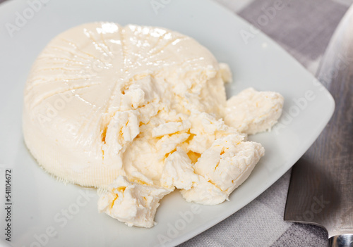 Appetizing fresh young curd cheese lying on a plate. Close-up image photo