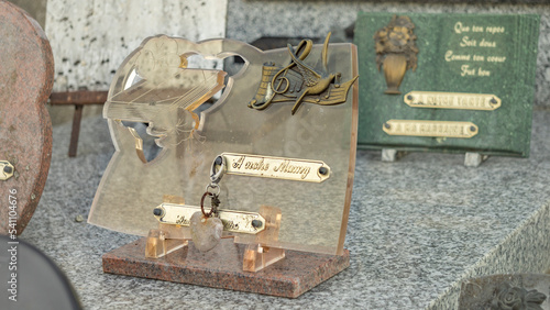 Transparent pink funeral plaque, decorated with a heart and a bird in flight on a musical score, with the inscription: "To our grandma"