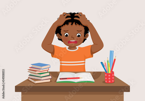 cute little African boy feeling stress tired and bored studying doing homework on the desk