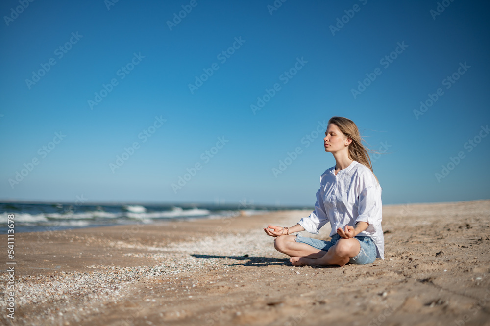 Girl practice meditation on the beach. With space for text or design Girl practice meditation on the beach. With space for text or design