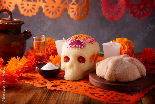 Pan de Muerto with sugar skull and Cempasuchil flowers or Marigold and Papel Picado. Decoration traditionally used in altars for the celebration of the day of the dead in Mexico photo