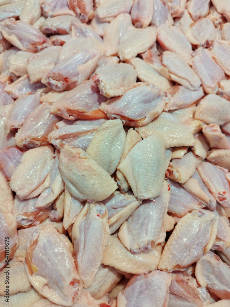 Raw chicken wings. Raw Buffalo Wings in red light. Perfect for Buffalo wing preparation. Fresh Chicken parts clean and from local farms. Raw chicken wings. Raw Buffalo Wings in red light. Perfect for Buffalo wing preparation. Fresh Chicken parts clean and from local farms.