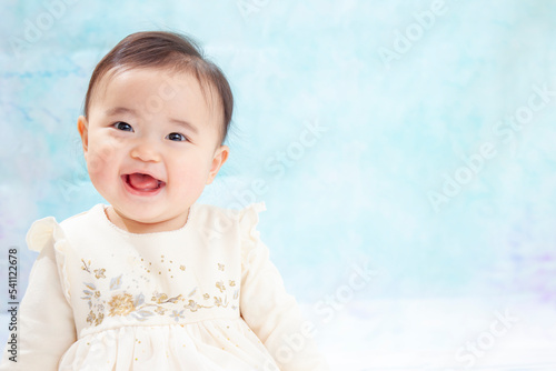 Naklejka ドレスを着て室内で遊ぶ笑顔の女の子の赤ちゃん