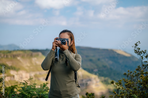 Young trekking female use camera photography on rocky mountain peak