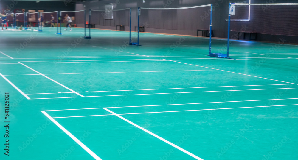 Many people playing badminton indoor Many people playing badminton indoor