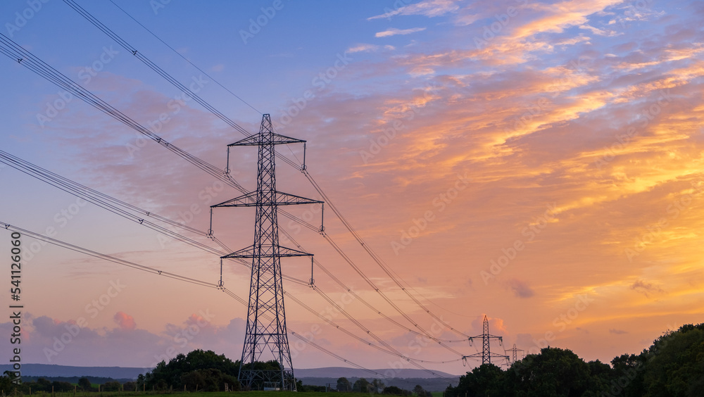 High voltage pole on silhouette sunset background