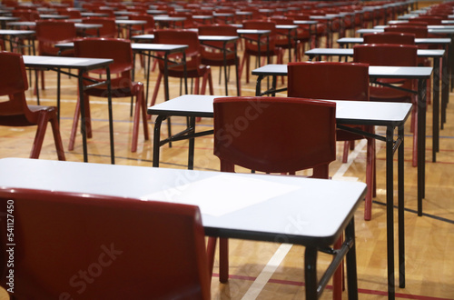 Bilde på lerret A large school hall filled with multiple exam tables and red chairs set up ready for major exams or student testing