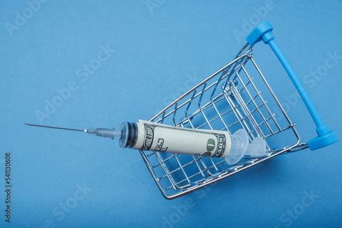 The syringe wrapped in a dollar is in the basket.