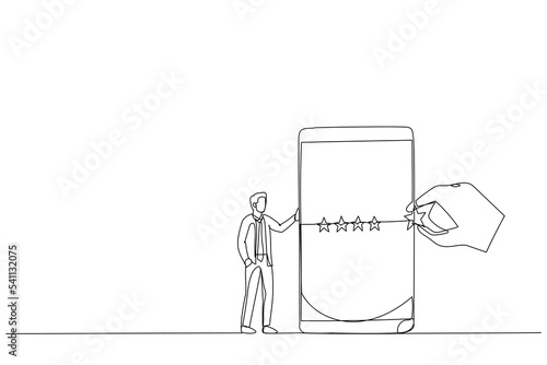 businessman standing with mobile phone with giant hand rating five stars