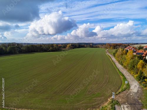 Aerial view. Field, path, clouds. Nature and greenery, a village. Polish landscape.