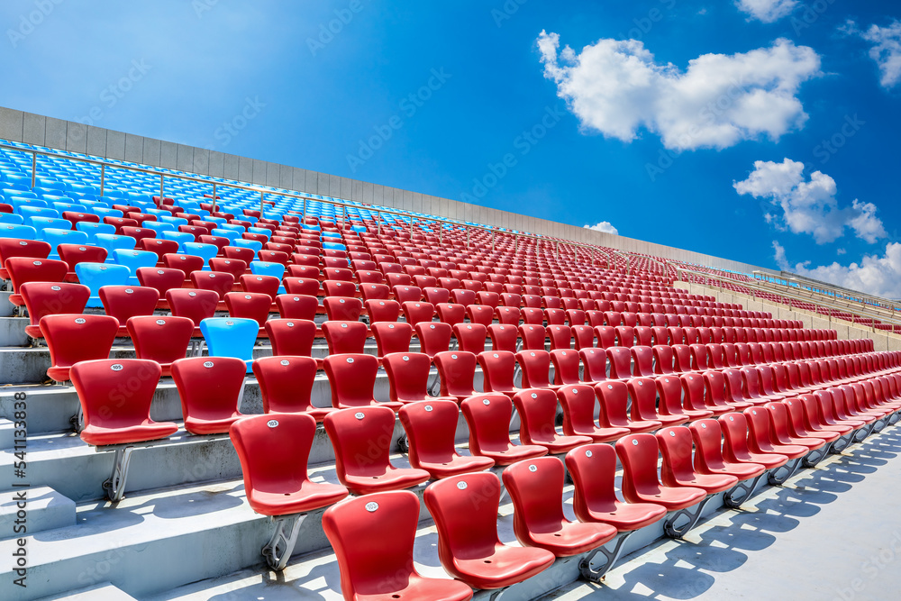 Fototapeta premium Red seats and beautiful sky clouds in the stadium