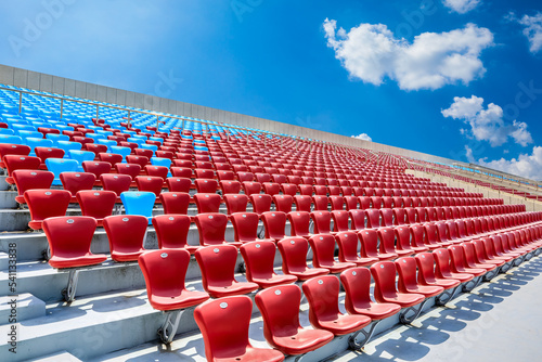 Red seats and beautiful sky clouds in the stadium